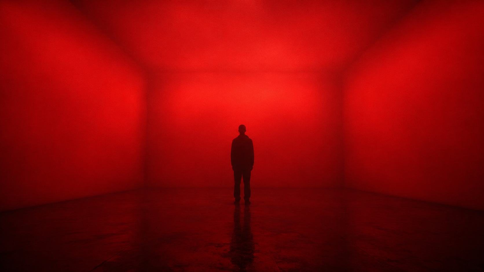 Interior of the Cube: a continuous saturated red LED field across four walls and the ceiling, dark floor, two visitors in silhouette.